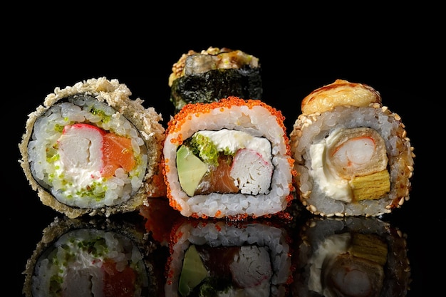 Rolki sushi różnych typów na czarnym tle