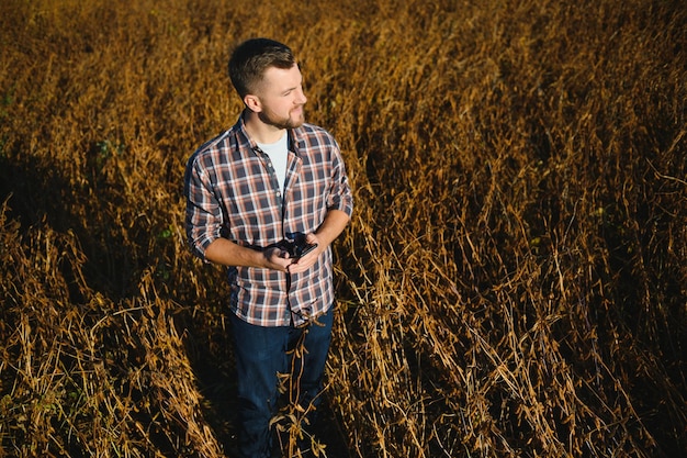 Rolnik agronom w polu soi sprawdzający uprawy przed zbiorami. Produkcja i uprawa żywności ekologicznej.