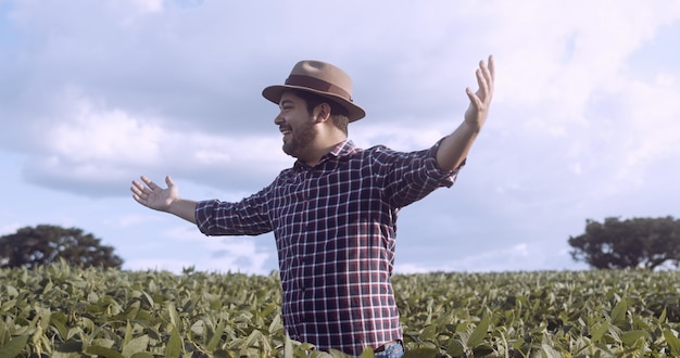 Rolnik dziękuje za żniwa lub deszcz. Plantacja soi. Brazylijska farma.