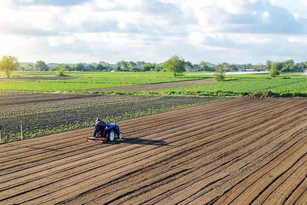 Rolnik na traktorze uprawia pole Uprawa gruntów Pracownik sezonowy Rekrutacja i zatrudnianie pracowników do pracy na farmie Rolnictwo rolnicze Prace przygotowawcze przed zasiewem nowej uprawy
