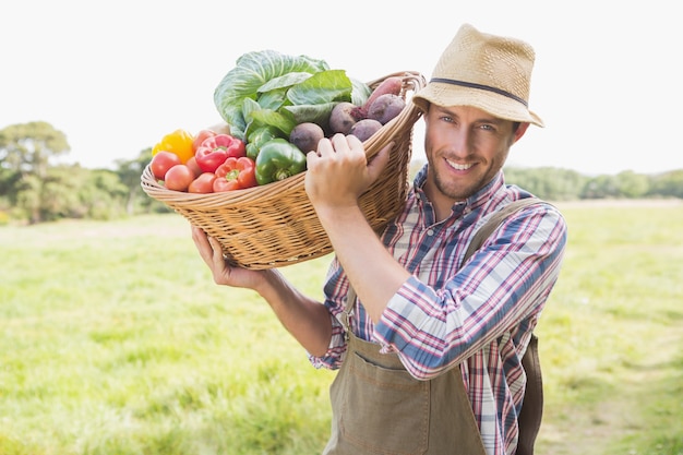 Zdjęcie rolnik niosący kosz z warzywami