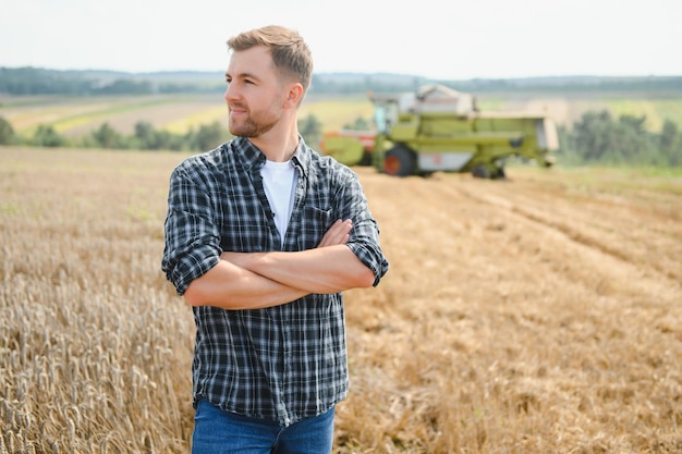 Rolnik stojący na polu pszenicy podczas żniw