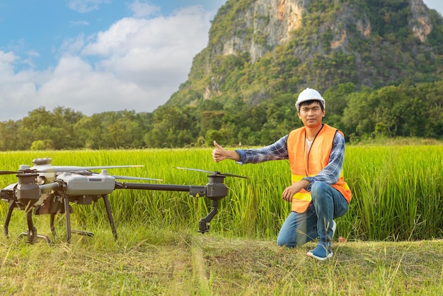 Rolnik W Czapce Stoi Na Bujnym Polu Pszenicy, Kierując Dronem Lecącym Nad Krawędzią Mężczyzna Kontrolujący Sprzęt Technologie Rolnicze