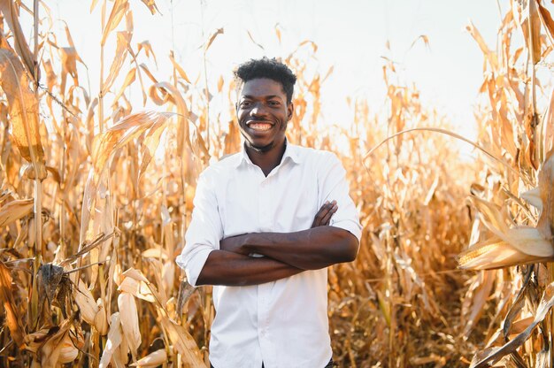 Rolnik ze swoją małą plantacją kukurydzy. Latynos w zwykłych ubraniach, stojący na polu.