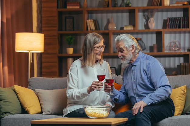 Romantyczna kochająca się starsza czuła para świętująca rocznicę w domu Szczęśliwe starsze osoby starsze Siwe włosy Rodzina ciesz się piciem i brzękiem kieliszkiem wina, aby zrelaksować się koncepcja emerytury Walentynki