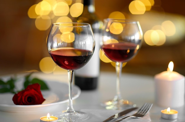 Romantyczna kompozycja z winem i świecą na rozmytym tle