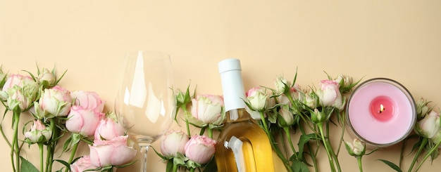 Romantyczna koncepcja z różami, winem i świecami na beżu