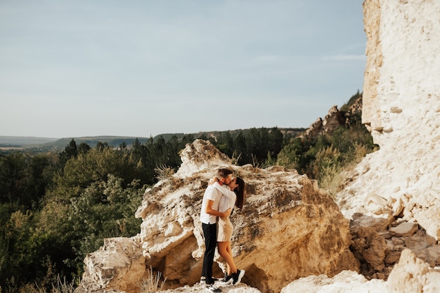 Romantyczna młoda para całuje namiętnie w górach lasu sosnowego.