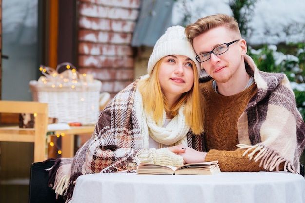 Romantyczna młoda para udostępnianie ciastek w kawiarni na świeżym powietrzu.