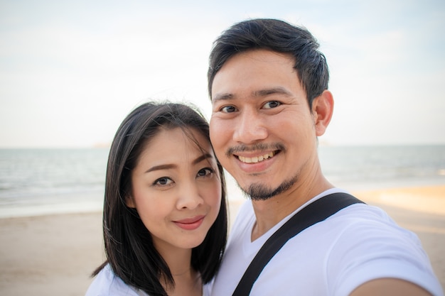 Romantyczna para bierze selfie fotografię na plaży.
