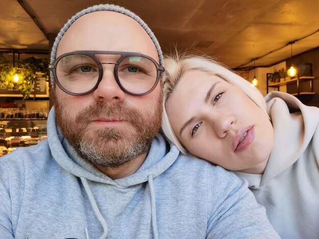 Romantyczna para biorąca selfie w kawiarni Młody mężczyzna w okularach z blond kobietą