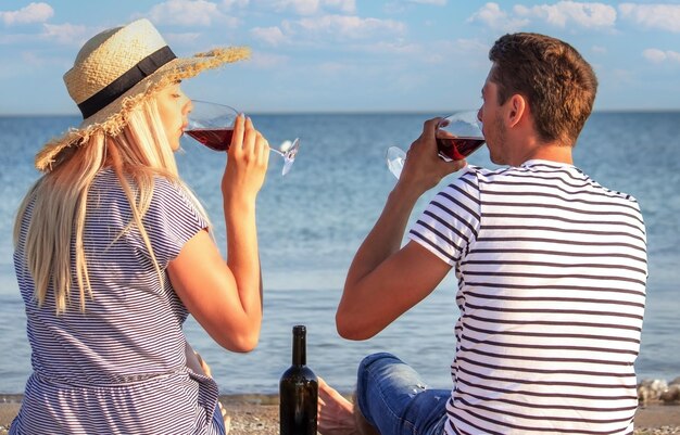 Romantyczna para delektująca się winem nad morzem?