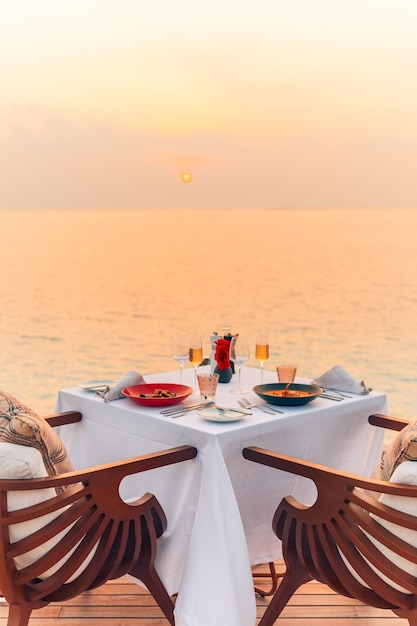 Romantyczna para kolacja na plaży Zachód słońca niebo i morze horyzont Koncepcja idyllicznej letniej kolacji na świeżym powietrzu