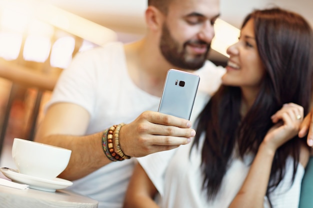 romantyczna para spotykająca się w kawiarni i robiąca selfie