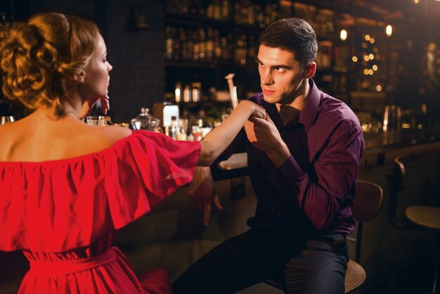 Romantyczna Randka W Restauracji, Atrakcyjna Kobieta W Czerwonej Sukience Flirtuje Z Mężczyzną Przed Blatem Barowym. Związek Miłosny, Nocny Styl życia