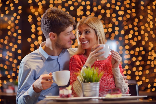 romantyczna randka w restauracji szczęśliwa młoda para z herbatą i ciastem w lampce wina