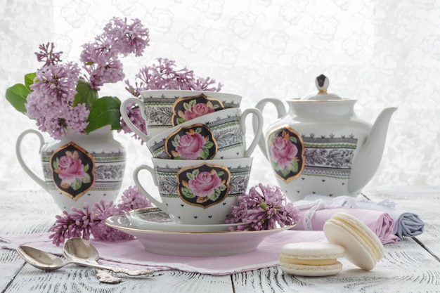 Romantyczna ściana z filiżanką herbaty, kwiatami bzu