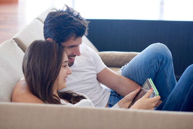romantyczna zrelaksowana młoda para w nowoczesnym domu przy użyciu komputera typu tablet