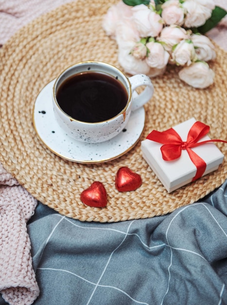 Romantyczne śniadanie z kawą, pudełkiem i kwiatami róży.