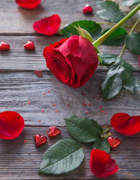 Romantyczne tło z czerwoną różą na drewnianym stole