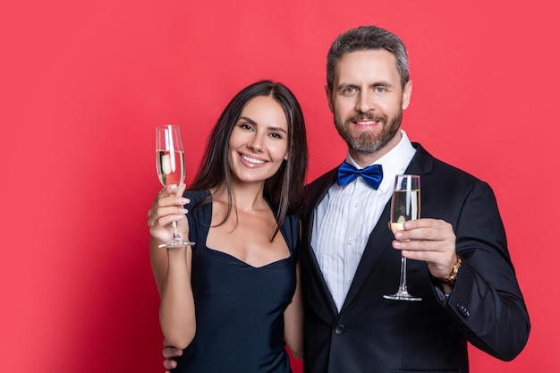 Zdjęcie romantyczne uroczystości randki dzień walentynek uroczystości rocznicy zakochana para świętuje zaręczyny elegantna para pije szampana odizolowana na czerwonym para przy uroczystej okazji świętowa para