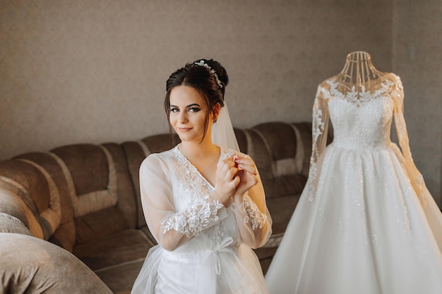 Romantyczny poranek panny młodej Panna młoda jest w domu Przygotowania do ślubu Panna młoda w pięknej szatce siedzi obok manekina w sukni ślubnej w domu Ciesz się każdą chwilą