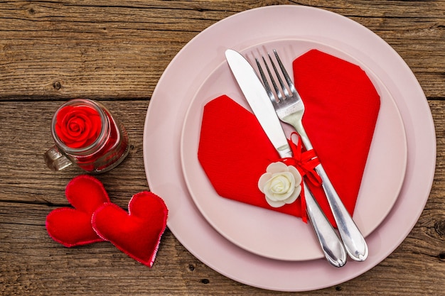 Romantyczny stół obiadowy z talerzami i serwetką w kształcie serca