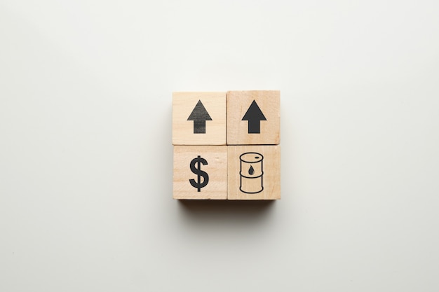 Ropa i dolarów wzrostowy pojęcie z ikonami na drewnianych blokach.