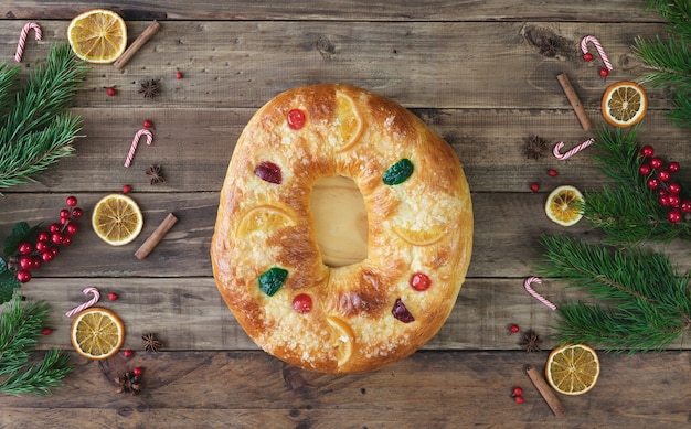 Zdjęcie rosca de reyes na drewnianej podstawie ze świątecznymi dekoracjami