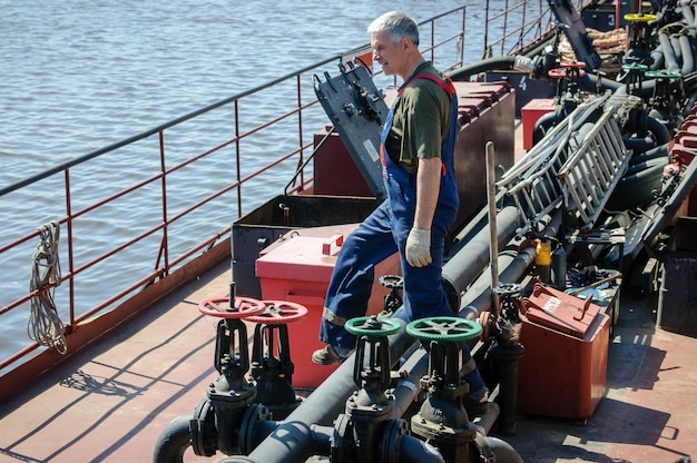 Zdjęcie rosja petersburg maj 2021 mężczyzna w marynarskim mundurze roboczym przy pracy na pokładzie morskiego tankowca