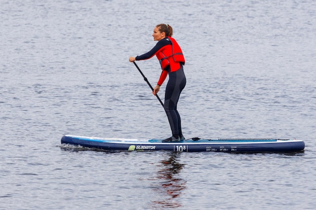 Rosja Vyborg 05092020 kobieta pływa na desce SUP po jeziorze