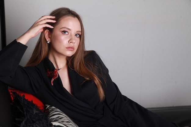 Rosyjski model mody w czarnym eleganckim garniturze leżący i odpoczywający na kanapie po długim dniu