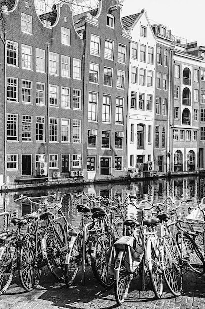 Zdjęcie rowery kanał wodny i typowa architektura w mieście w amsterdamie