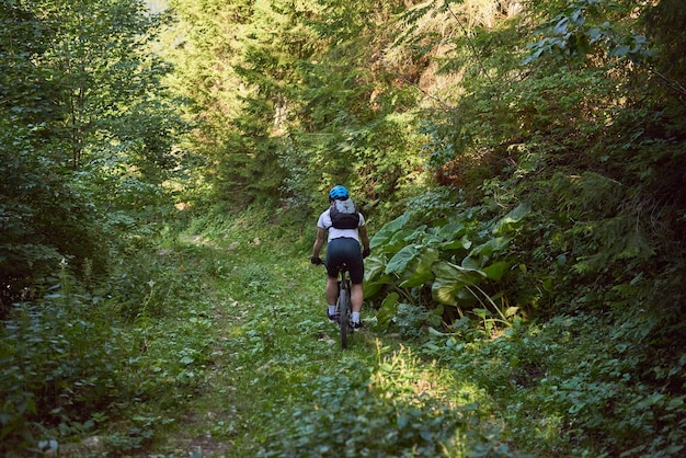 Rowerzysta jeździ na rowerze po ekstremalnych i niebezpiecznych leśnych drogach Selektywne skupienie
