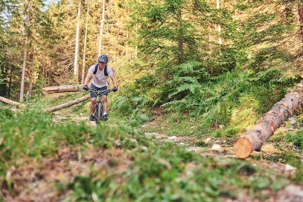 Rowerzysta jeździ na rowerze po ekstremalnych i niebezpiecznych leśnych drogach Selektywne skupienie