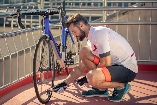 Rowerzysta sprawdzający koło swojego roweru