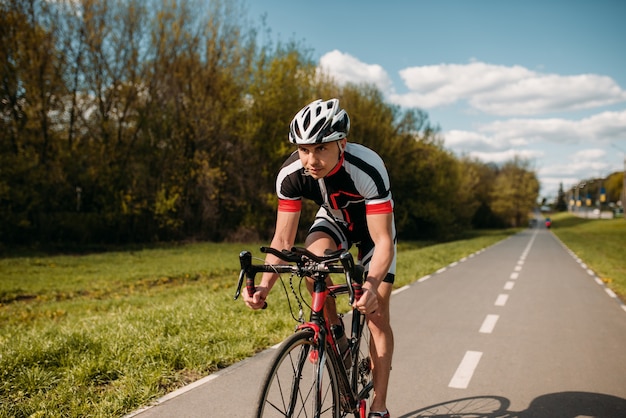 Rowerzysta W Kasku I Odzieży Sportowej Na Treningu Rowerowym. Trening Na ścieżce Rowerowej, Jazda Na Rowerze