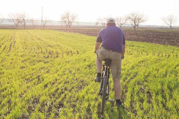 Rowerzysta w krótkich spodenkach i koszulce na nowoczesnym rowerze hardtail z włókna węglowego z widelcem pneumatycznym