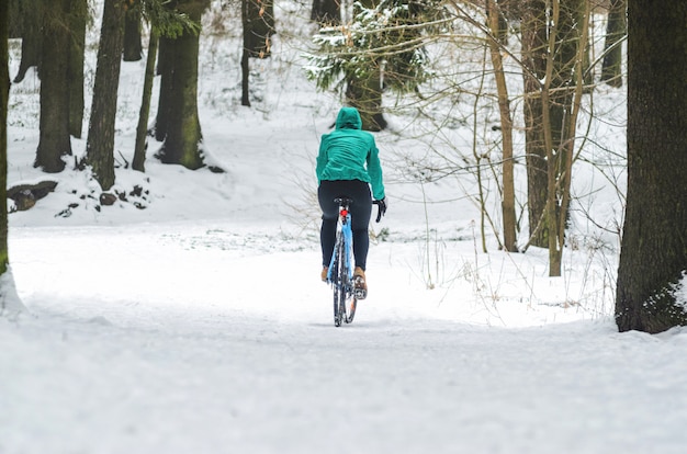 Rowerzysta w śnieżnym lesie