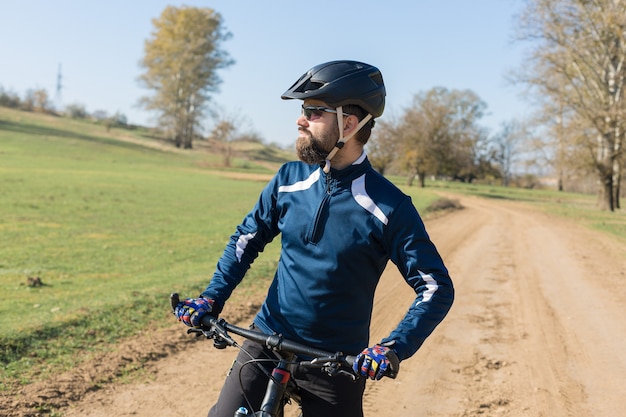 Rowerzysta w spodniach i polarowej kurtce na rowerze hardtail z widelcem pneumatycznym jeździ w terenie