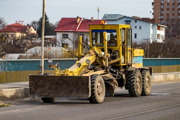 Zdjęcie równiarka jeździ na drodze w mieście.