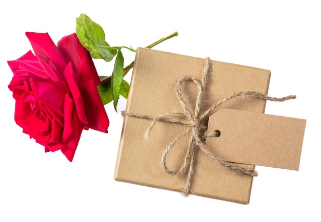 Różany czerwony kwiat i pudełko z pustą etykietą na białym tle widok z góry miejsce na tekst