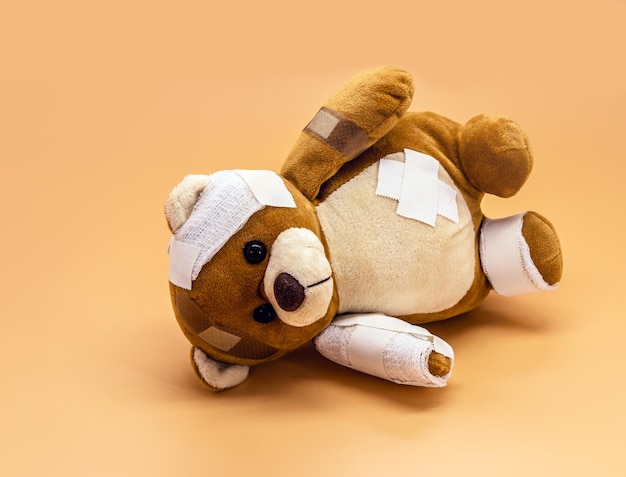 Rozdarta zabawka dla dzieci z bandażami i koncepcja bandaży przemocy w dzieciństwie lub agresji dzieci