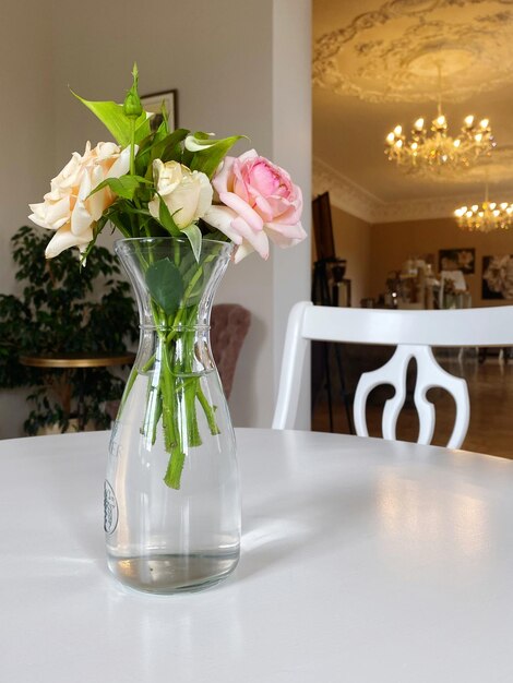 Zdjęcie róże w szklanym wazonie na stole