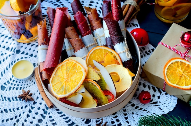 Rozgrzewająca herbata w zimowy wieczór bożonarodzeniowy z pomarańczami, chipsami owocowymi i prezentami