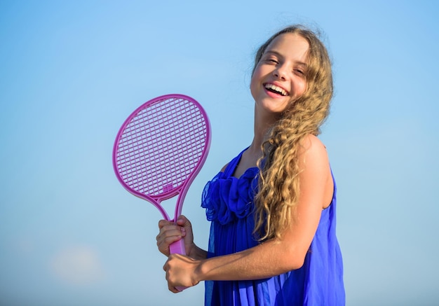 Rozgrzewka gra w tenisa dzieciństwo szczęście zdrowy styl życia mała dziewczynka z rakietą tenisową lato aktywność sportowa energiczne dziecko szczęśliwe i wesołe sportowa gra gra w letnie gry na świeżym powietrzu