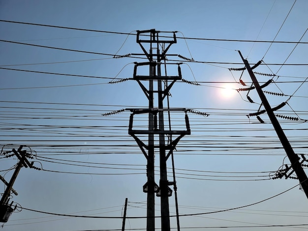 Rozłącznik obciążenia 115 kV w pozycji zamkniętej na błękitnym niebie, na tle świecącego słońca