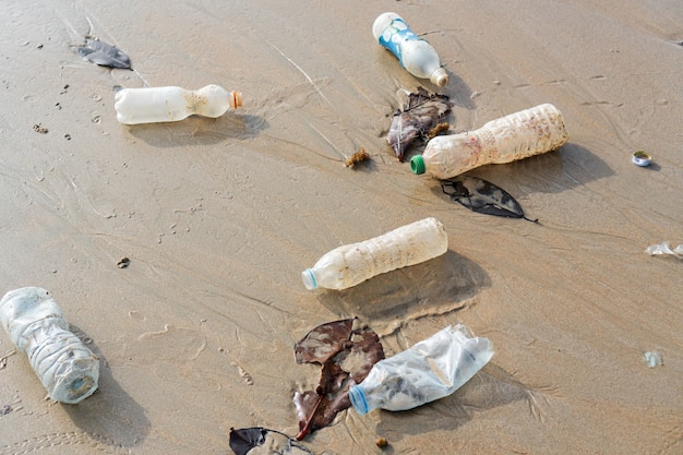 Rozlane Plastikowe śmieci Porzucone Na Plaży Wielkiego Miasta. Opróżnij Zużyte Brudne Butelki Na Piasku. Zanieczyszczenie środowiska, Koncepcja Problemu Ekologicznego.