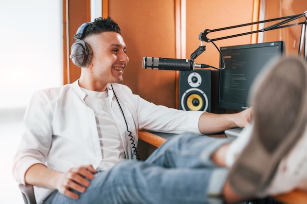 Rozmawia i używa mikrofonu Młody człowiek jest w środku w studiu radiowym jest zajęty przez transmisję