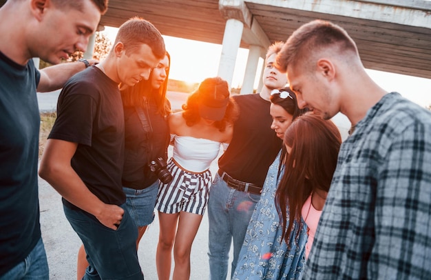 Zdjęcie rozmawianie i śmiech grupa młodych, wesołych przyjaciół bawiących się razem impreza na świeżym powietrzu
